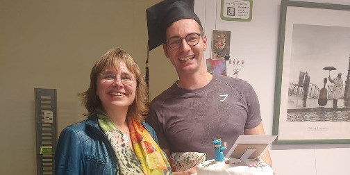 Betreuerin und Promovend feiern mit Kuchen