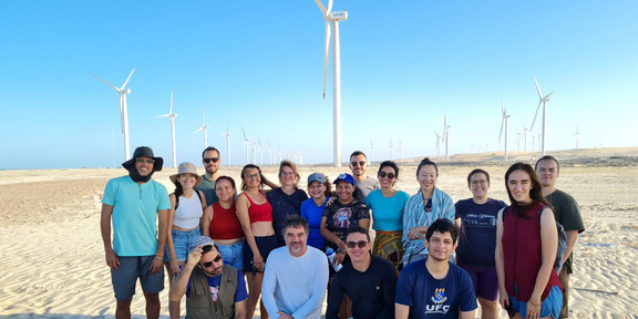 Photo of the group on the beach in front of many wind turbines